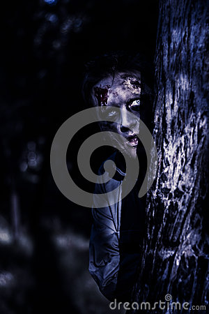 Dark Evil Portrait Of A Creepy Zombie Man Peering From Behind Trees In    