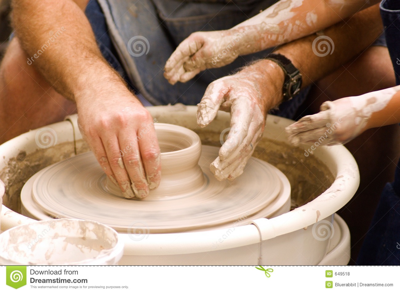 Adult And Child Hands Shaping A Pot On A Turning Pottery Wheel