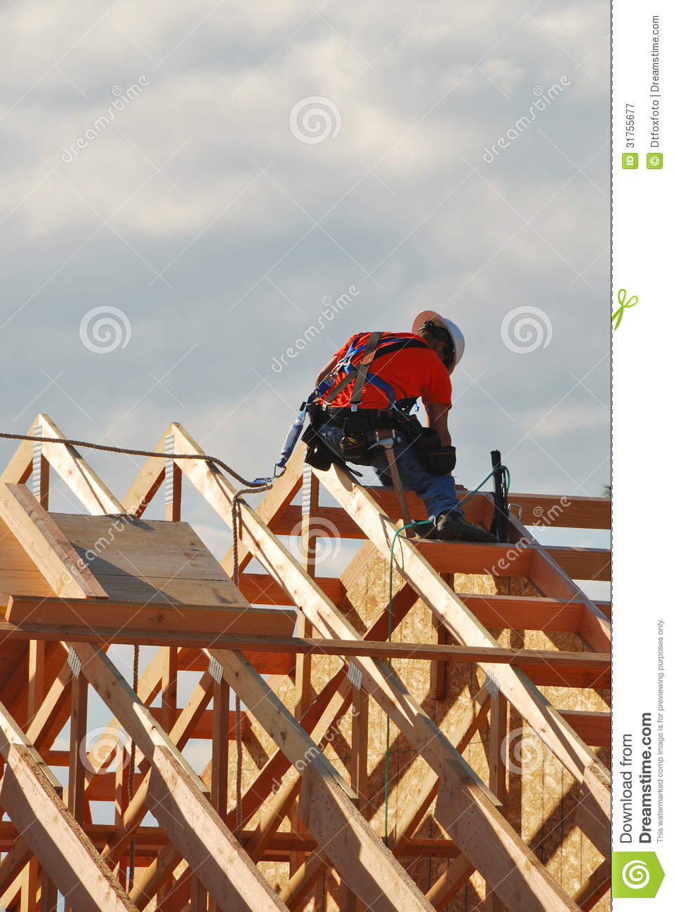 Worker Tying In The Final Roof Rafters On A New Bank Building In