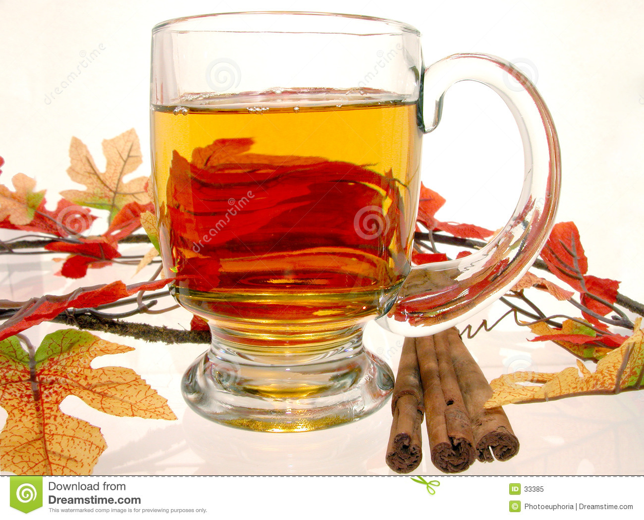 Glass Mug Of Hot Apple Cider Surrounded By Fall Decorations And