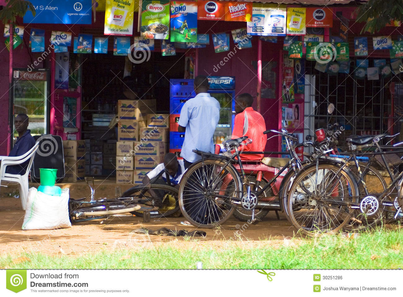 Man Repairs Bicycles Outside A Small Village Market In Africa 