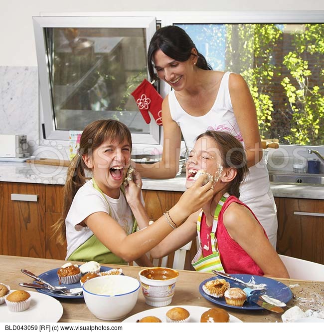 Hispanic Sisters Decorating Cupcakes And Being Silly   Stock Photos    