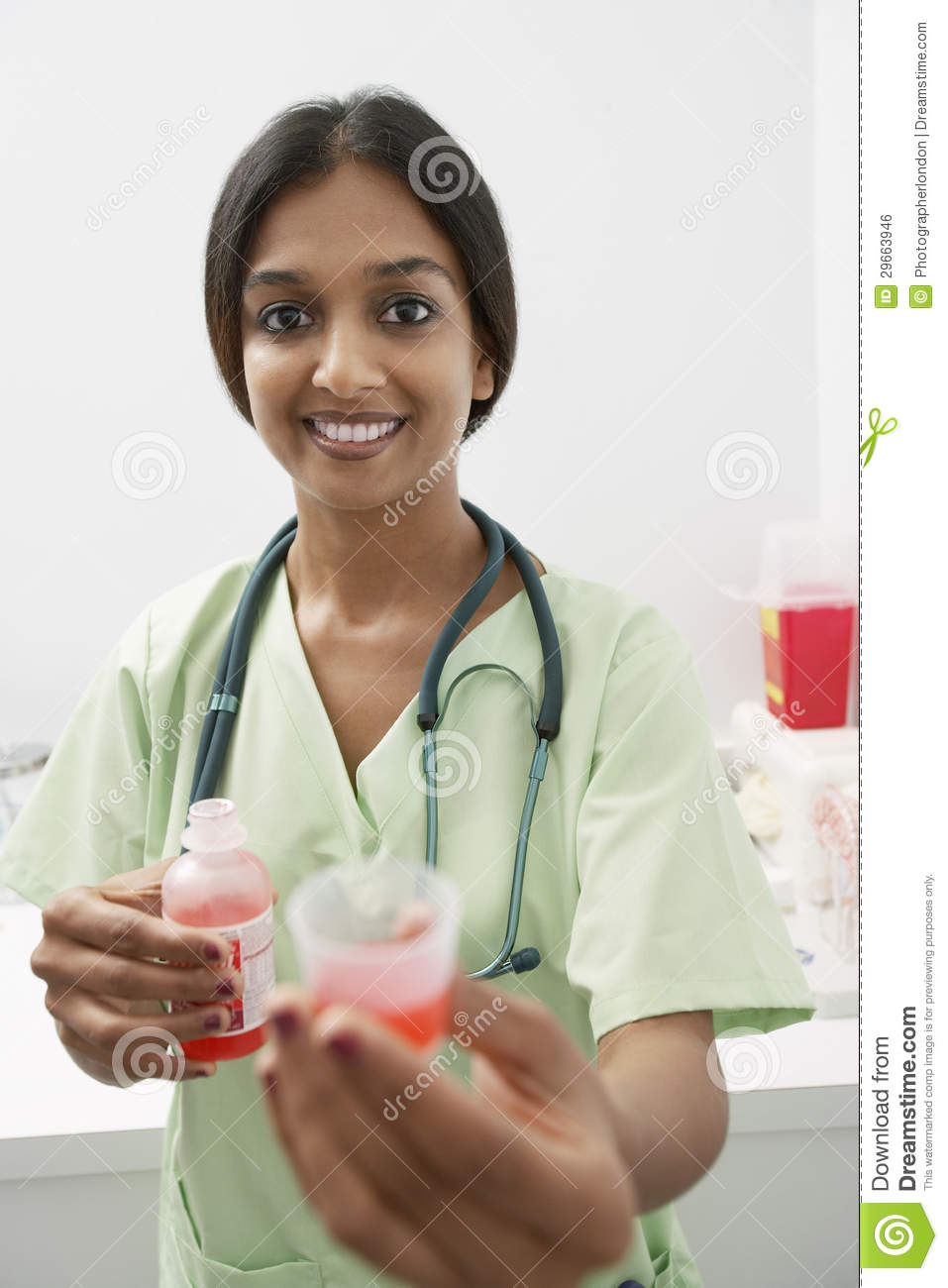     Of A Happy Indian Doctor Holding Out Medicine In Liquid Measure