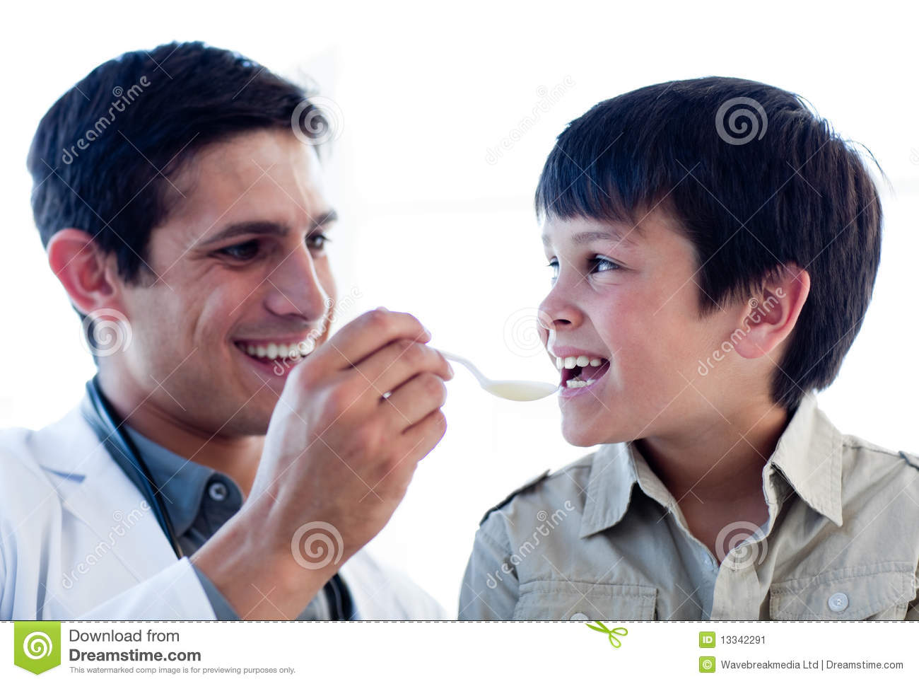 Self Assured Doctor Giving Medicine To A Little Boy Against A White