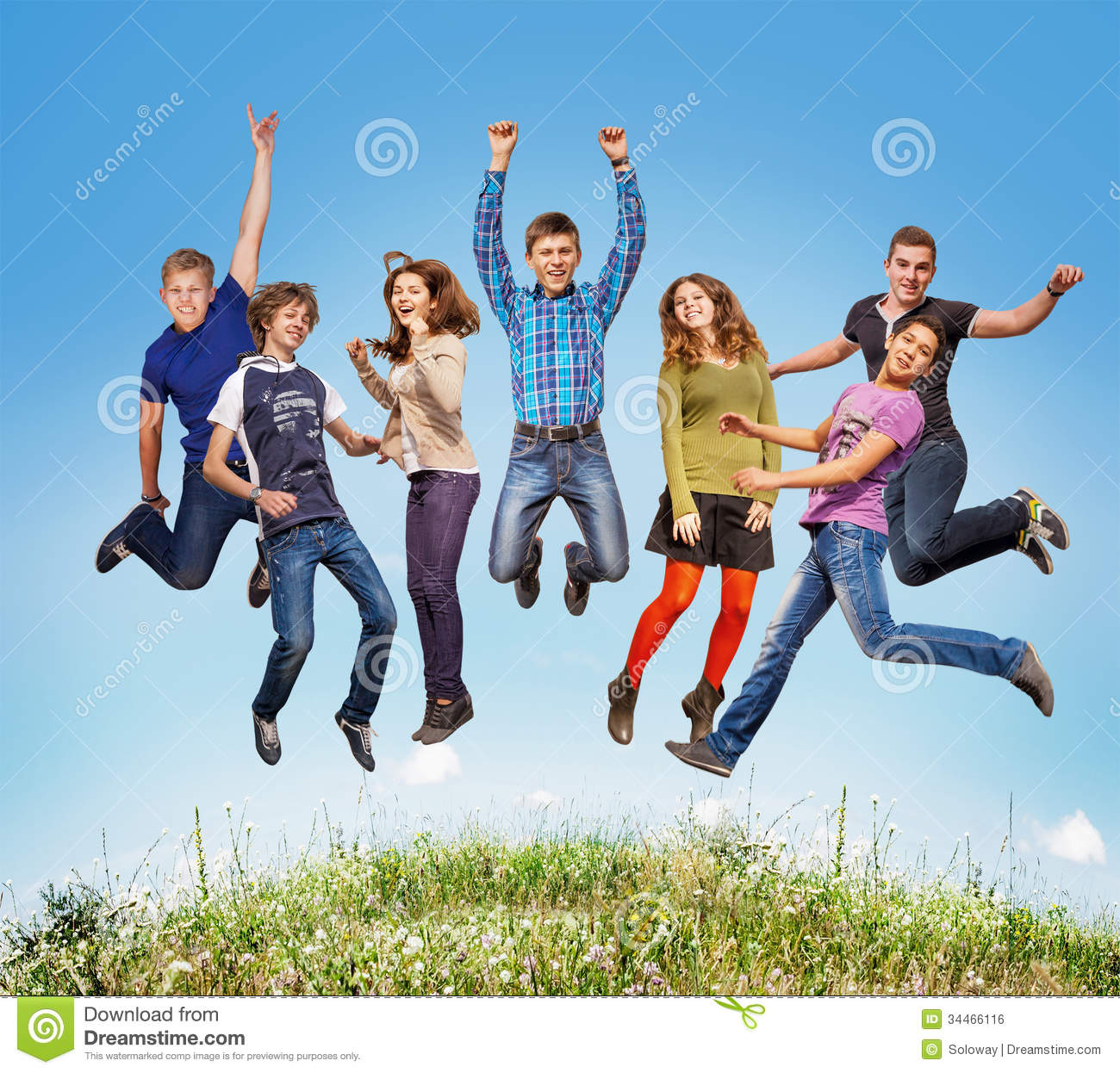 Group Of Teens Jumping In The Blue Sky Above The Green Grass