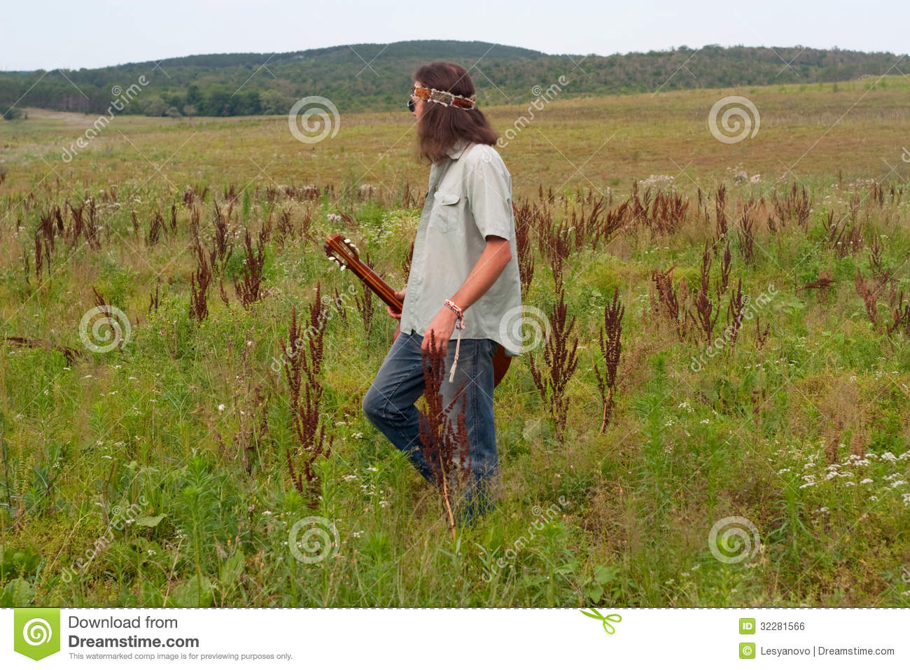 Hippie Musician With Guitar On The Meadow Royalty Free Stock Image
