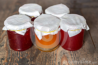 Strawberry And Apricot Marmalade On A Wooden Table