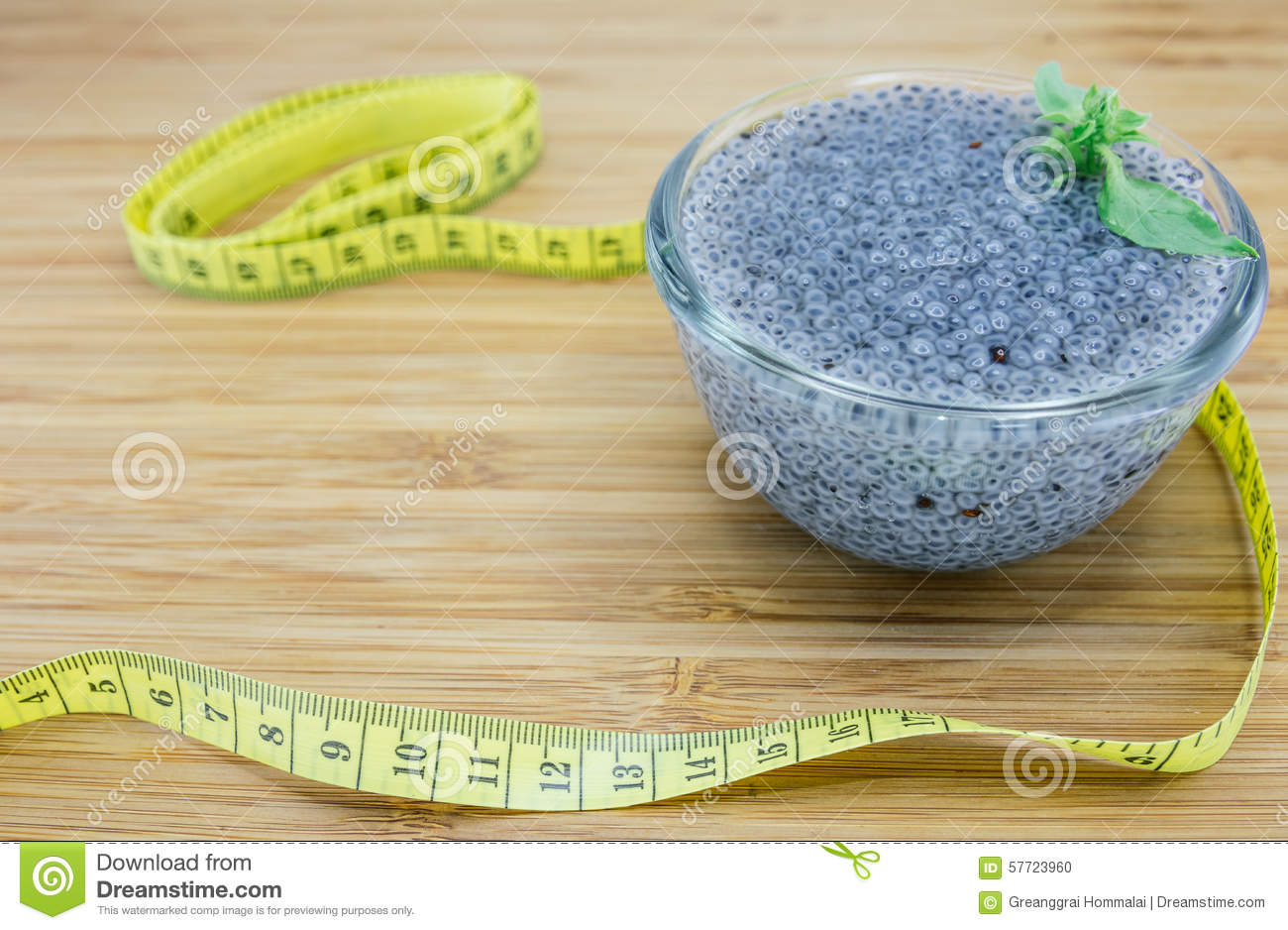 Basil Seeds In A Glass Bowl And Measuring Tape On Wood Background