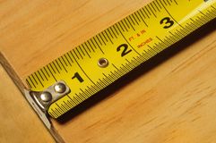 Yellow Tape Measure Measuring A Piece Of Wood Royalty Free Stock