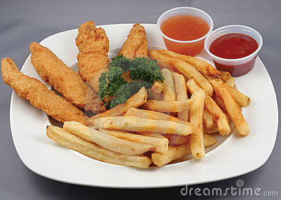 Plated Meal Of Chicken Strips And Fries With Ketchup And Dipping Sauce