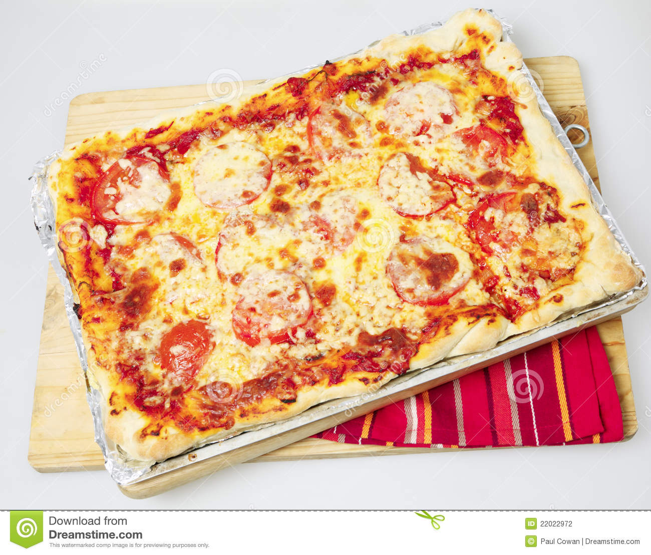     Rectangular Pizza With Cheese And Tomato Topping On A Baking Sheet
