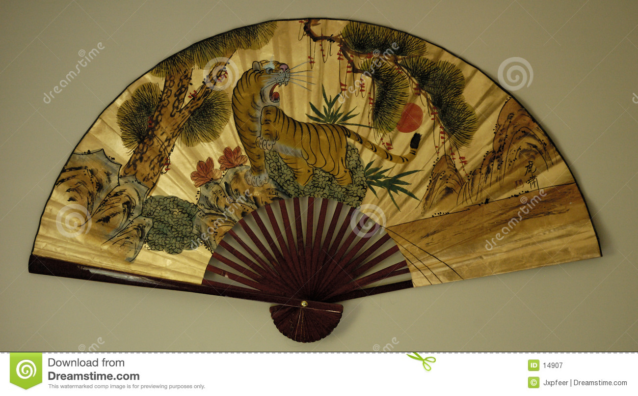 Large Decorative Asian Fan Hanging On A White Wall  The Fan Has A    