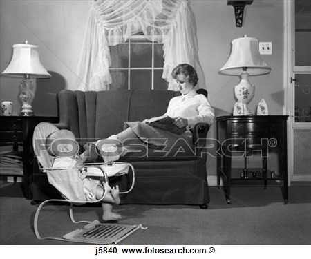 1950s Teen Babysitter Seated On Sofa Reading Schoolbook While Baby In    