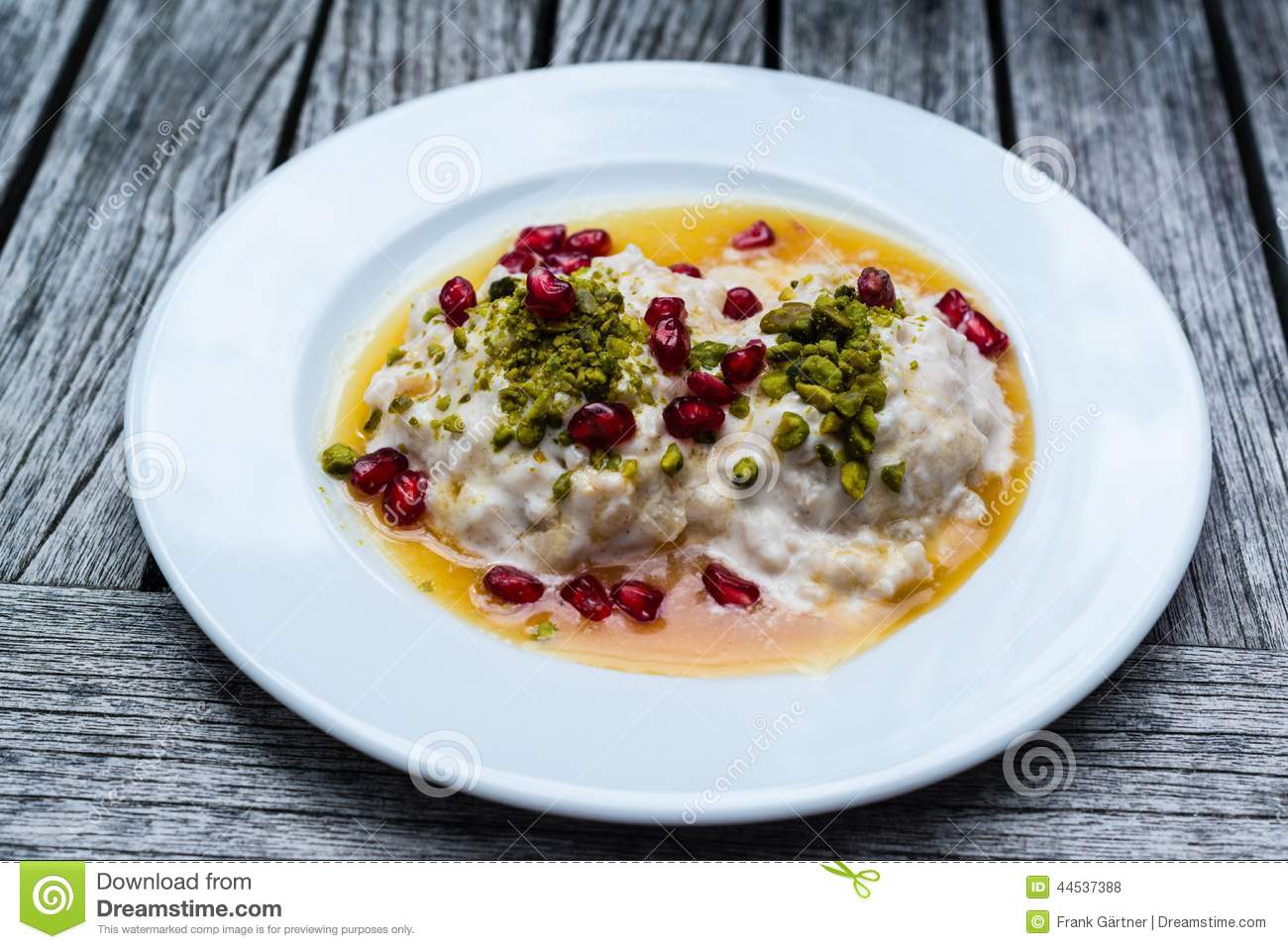 Rice Pudding With Cinnamon Pistachios And Pomegranates On Wooden    