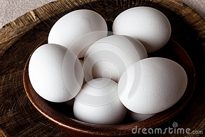 White Eggs In A Brown Clay Cracked Bowl On Wooden Old Weathered