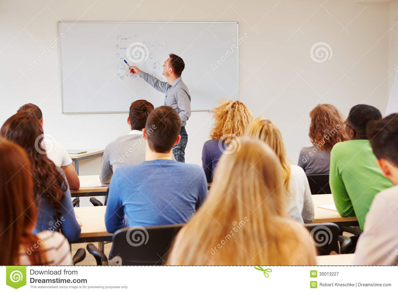 Students Listening To Teacher In Class On A Whiteboard