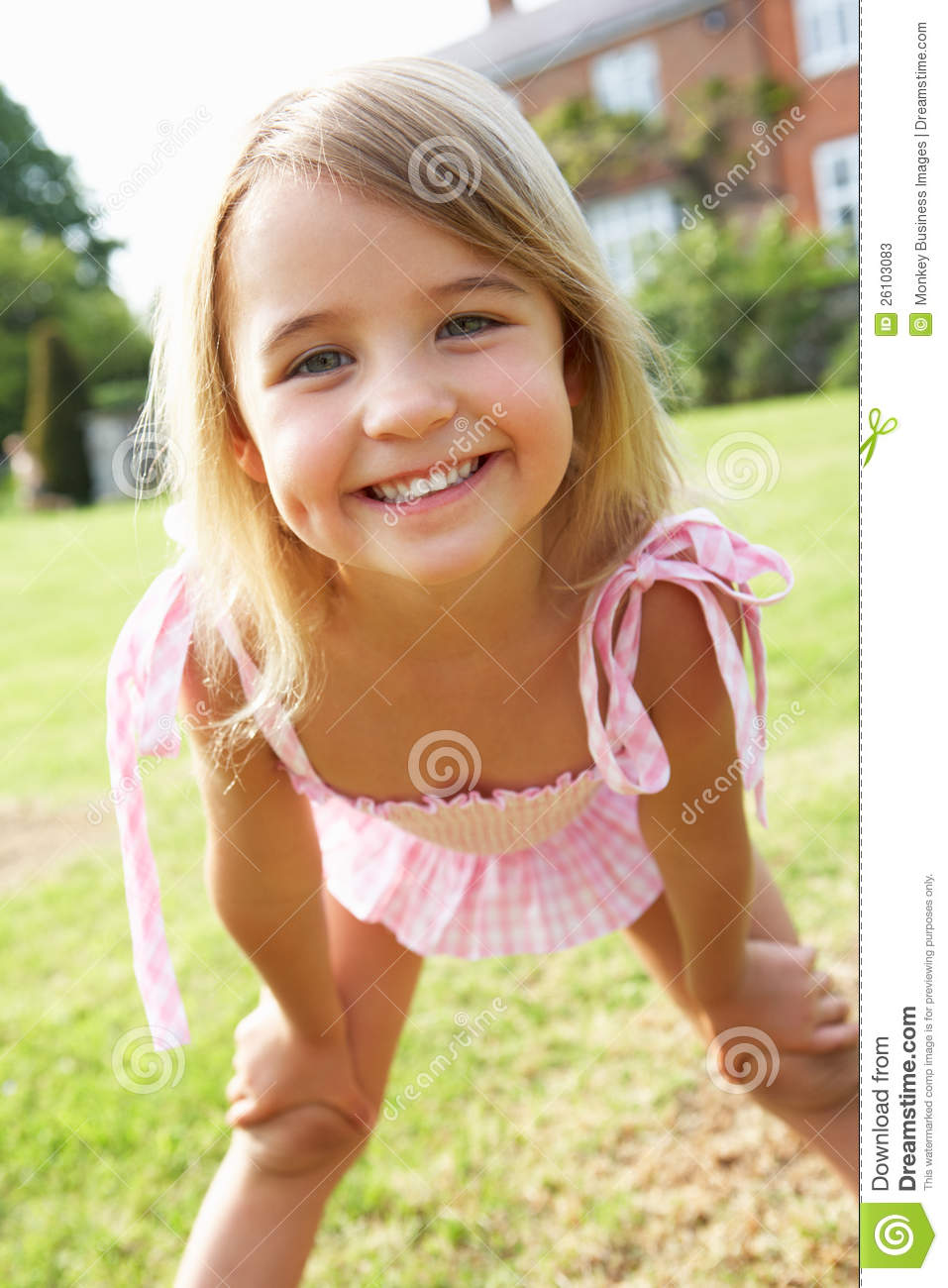 Portrait Of Young Girl Standing In Garden Wearing Swimming Costume