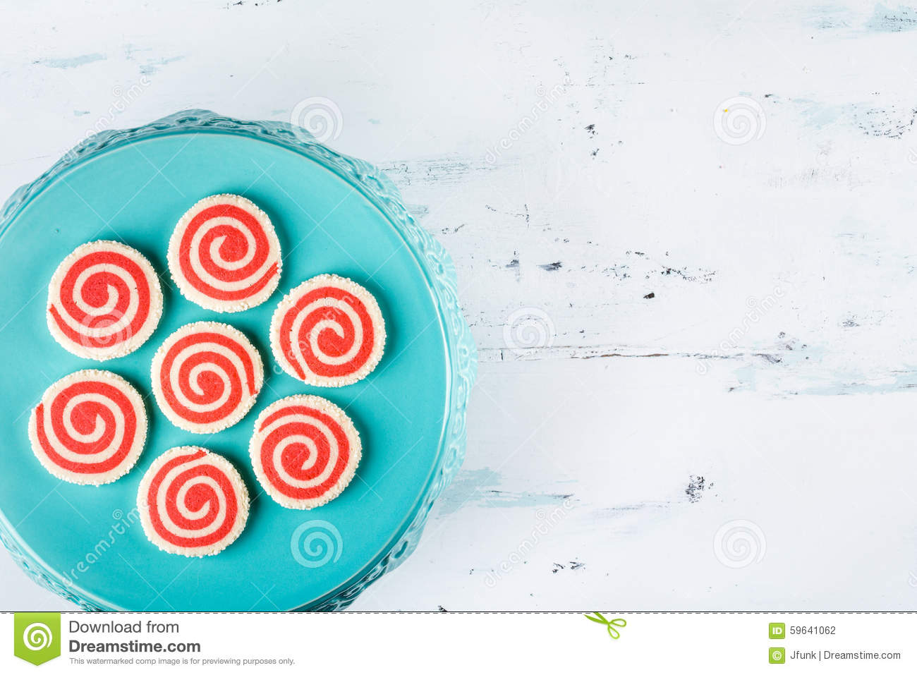 Red And White Pinwheel Christmas Cookies On A Teal Plate