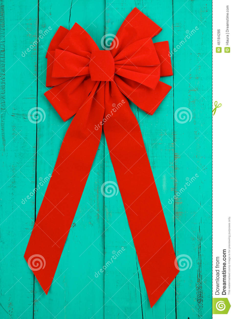 Red Velvet Christmas Bow And Ribbon Hanging On Antique Teal Blue