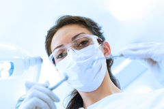 Dentist In Mask Holding Angled Mirror And Drill Royalty Free Stock
