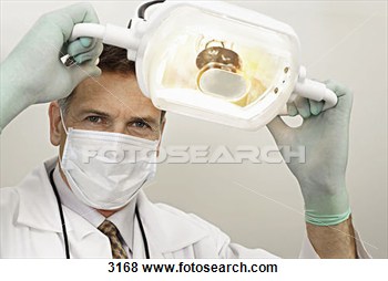 Dentist In Surgical Mask And Gloves Adjusting Surgical Light Low View