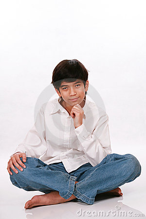 Twelve Year Old Boy Sitting Thinking With Chin On Hand And Smiling