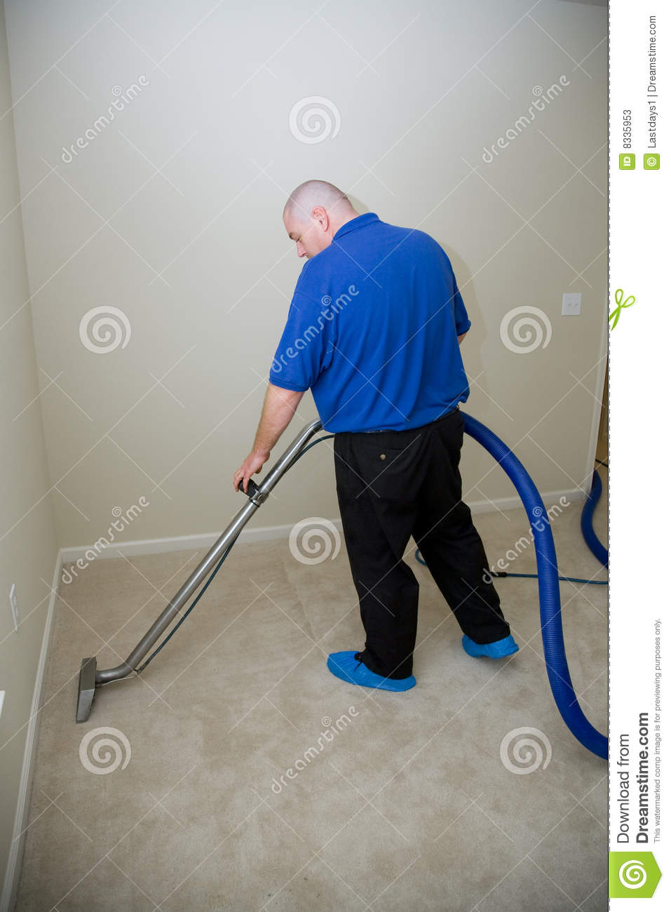 Man Cleaning Carpet And Removing Stains With Commercial Equipment