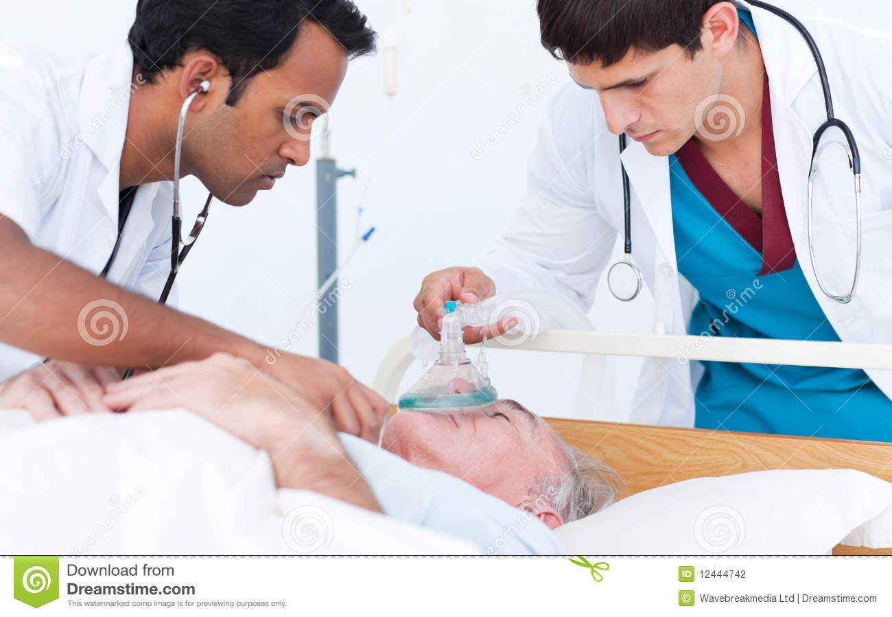    Doctor Putting Oxygen Mask On A Senior Patient In An Emergency Unit