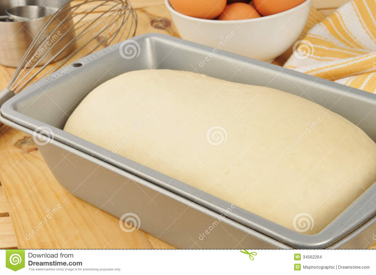 Bread Dough Rising In A Baking Pan With Brown Eggs In The Background 
