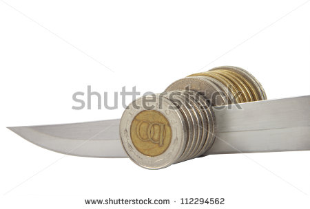 Knife Cutting A Pile Of Coin  Concept Of Money Reduction Budget Cuts