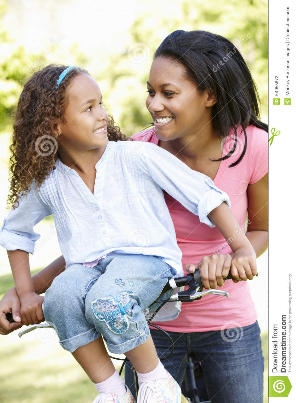 Young African American Mother And Daughter Cycling In Park Stock Photo