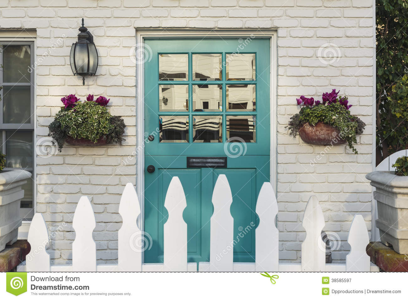 Teal Wooden Front Door To A Home With White Picket Fence Gate In
