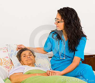 Smiling Nurse Caring For Kind Elder Patient In Nursing Home