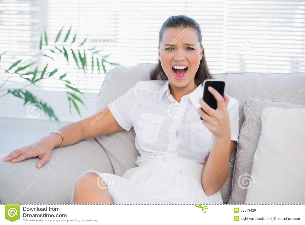 Angry Woman Holding Her Phone Screaming At Camera Stock Photo   Image