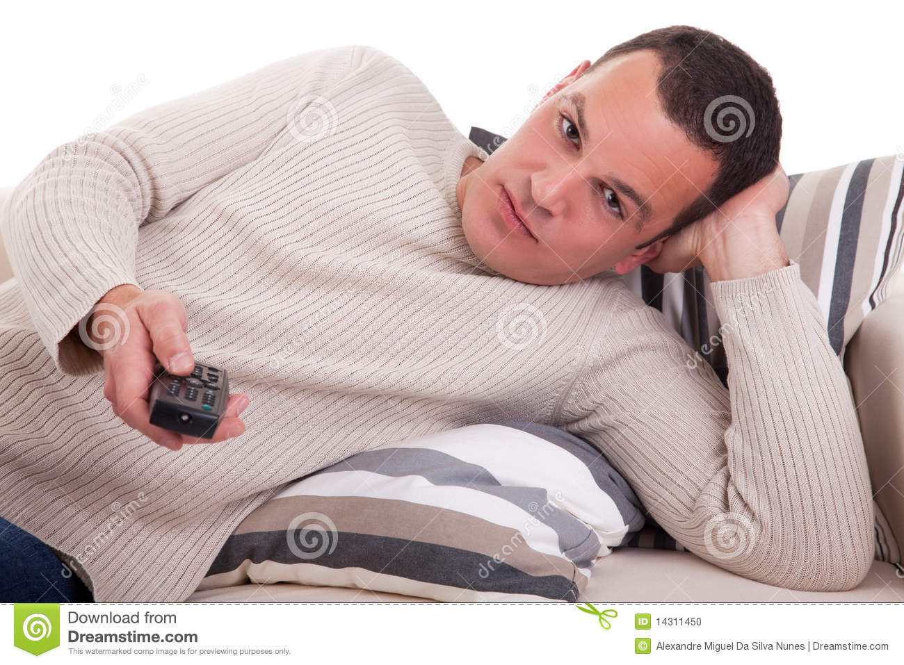 Casual Man Lying On The Couch Watching Television With The Command