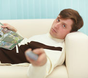 Man Lying On Couch With Magazine Stock Images
