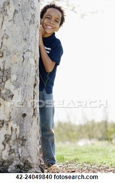 Little Boy Hiding Behind A Tree Trunk View    