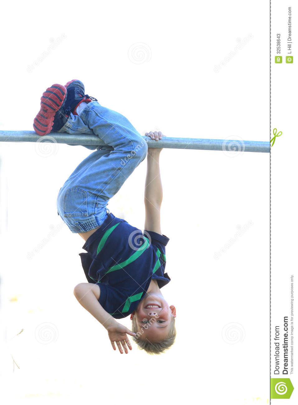 Young Boy Hanging From A Bar Upside Down Smiling And Waving 