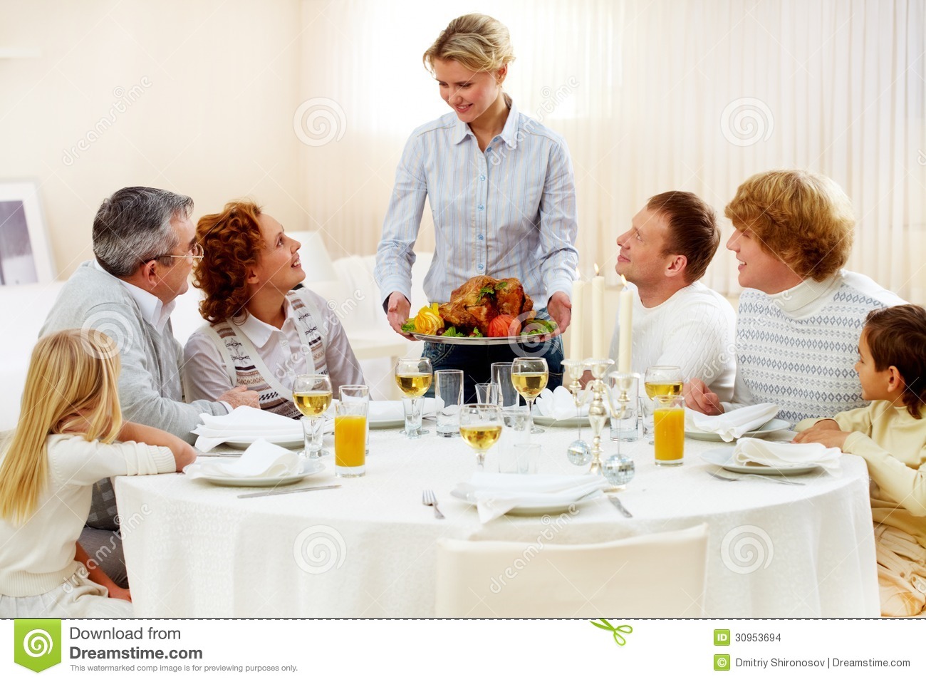 Portrait Of Big Family Sitting At Festive Table And Looking At Pretty