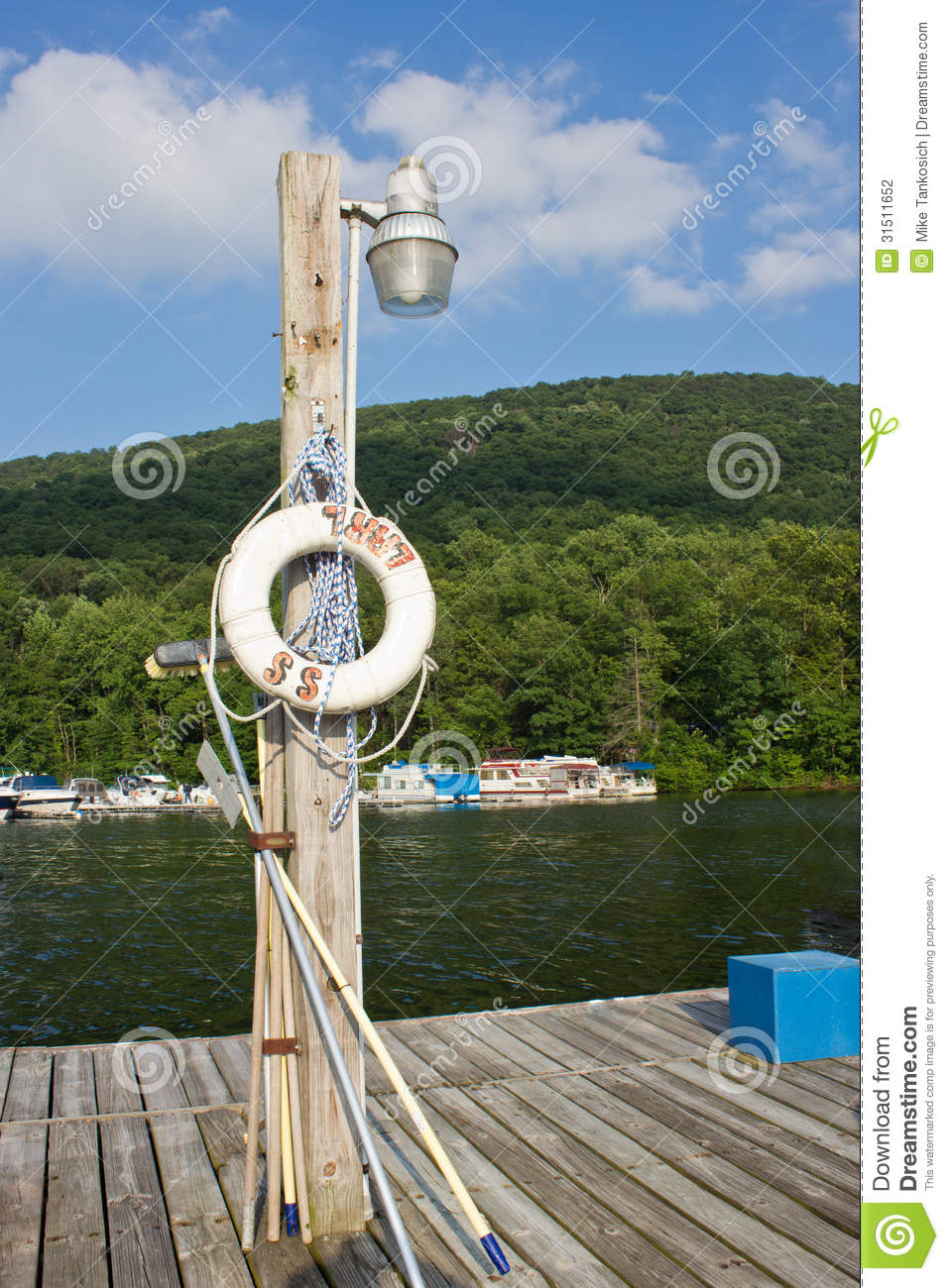 Raft And Other Tools Hang On A Wooden Lamp Post On A Wood Boat Dock