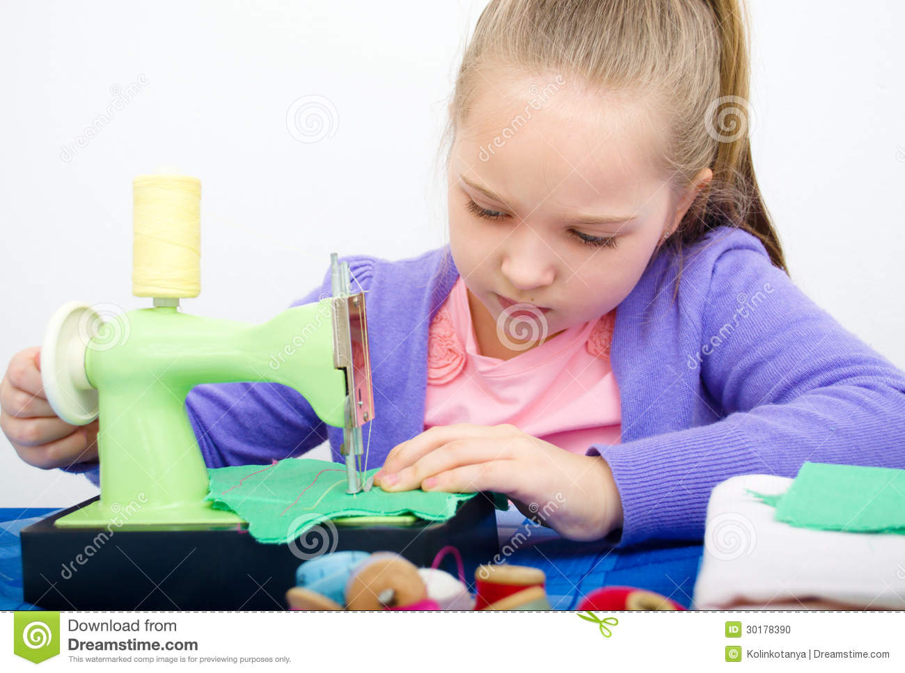 Cute Girl Sewing On A Sewing Machine At Home