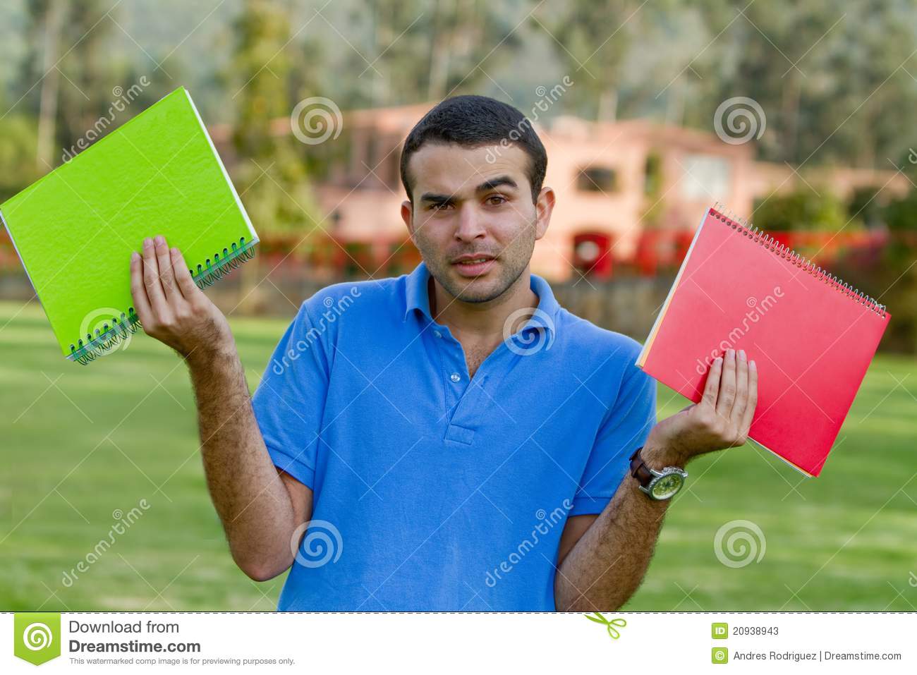 Uncertain Male Student Holding Notebooks Outdoors 
