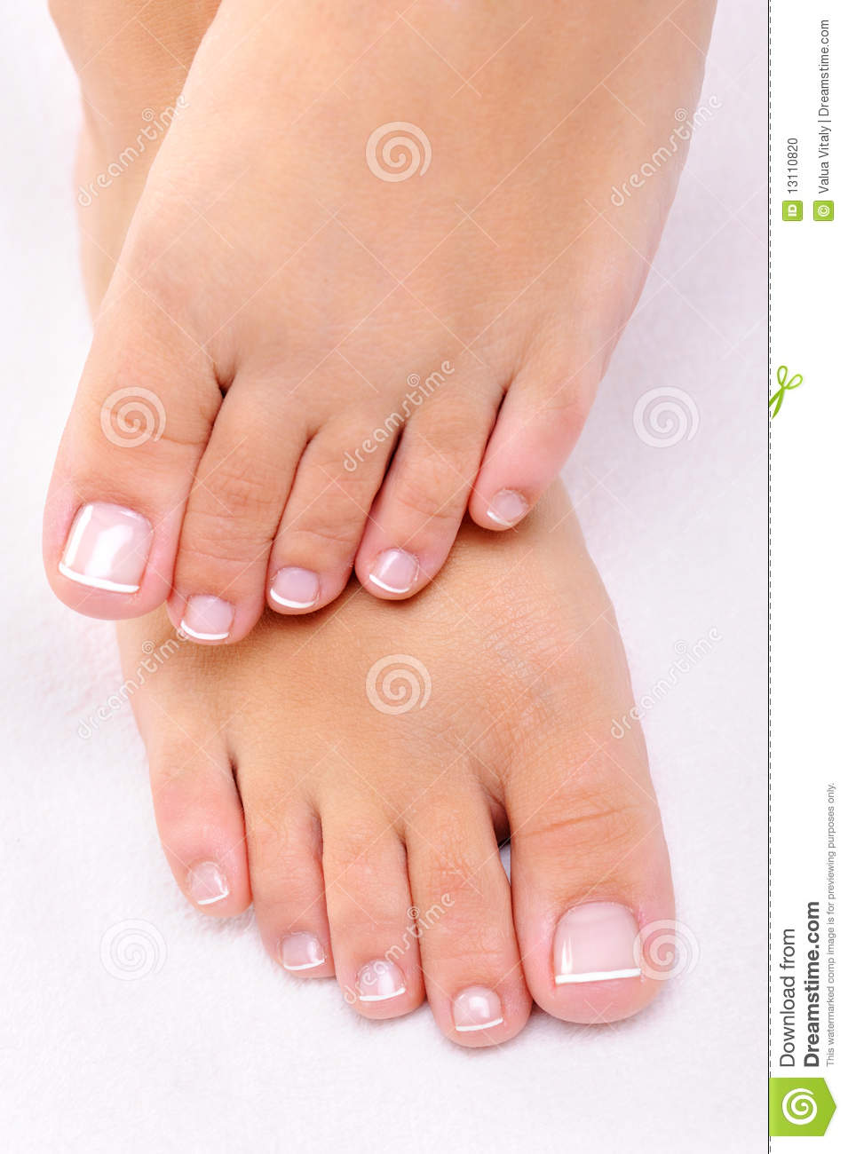 Beautiful Female Feet With The French Pedicure On A White Towel 