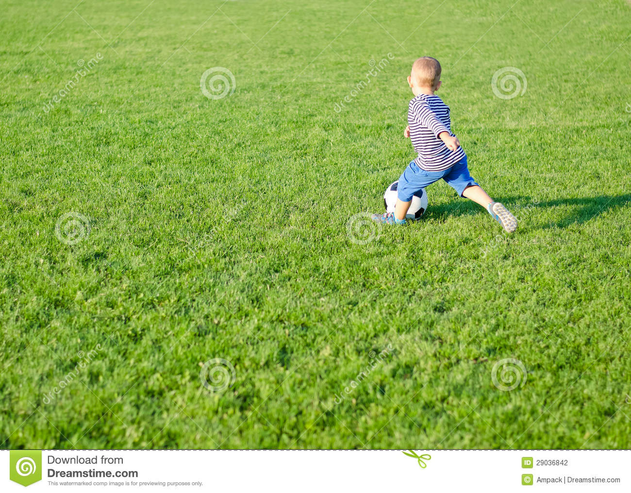 Grassy Sportsfield Dribbling The Ball Alongside Him With Copyspace