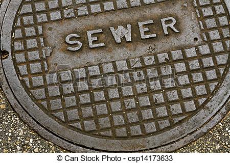 An Old Grungy Steel Metal Sewer Manhole Cover In An Asphalt Paved Side    