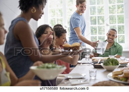 Family Gathering Men Women And Children Around A Dining Table    