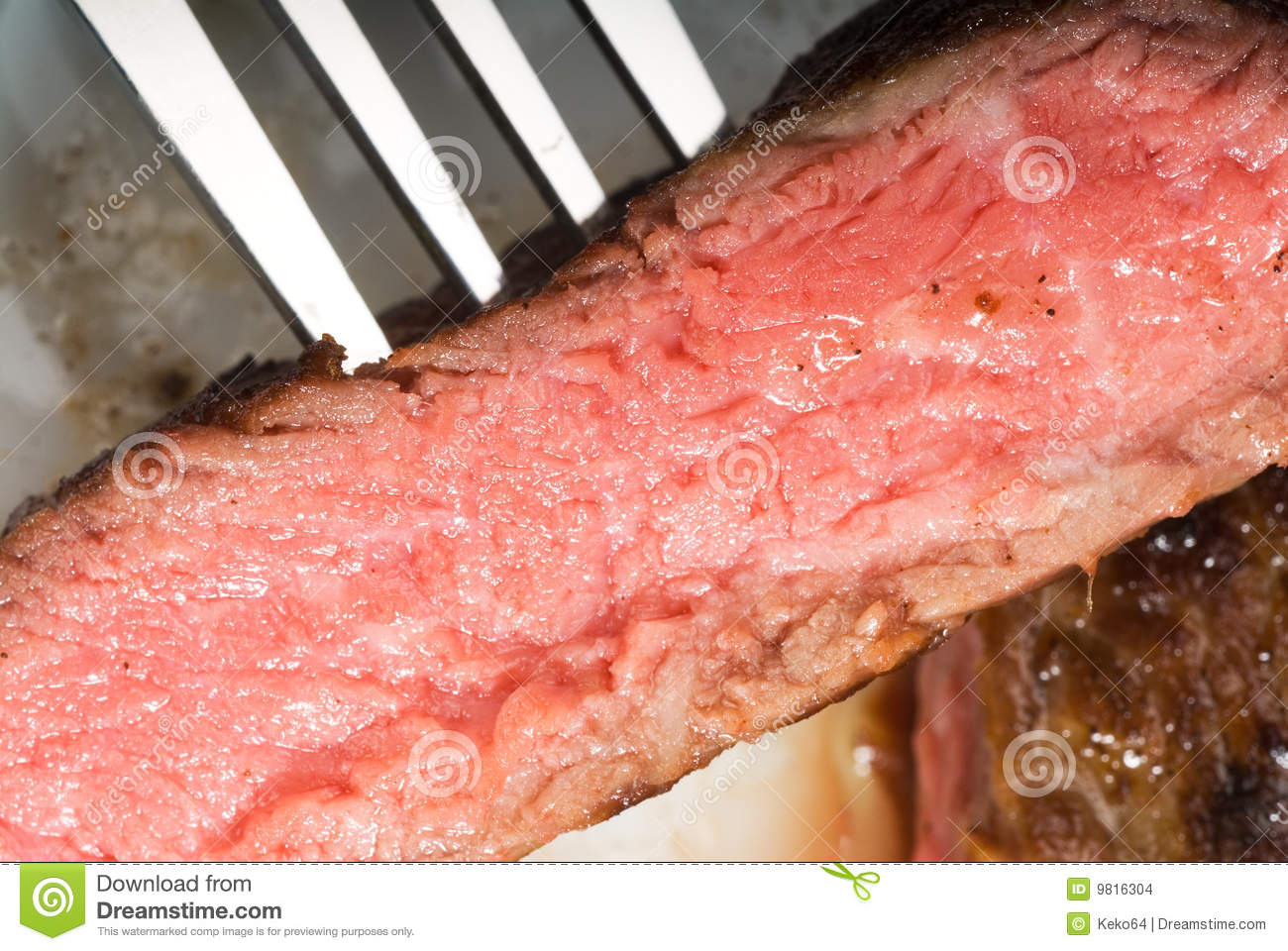 Fresh Juicy Beef Ribeye Steak Sliced With Fork Ove A Plate