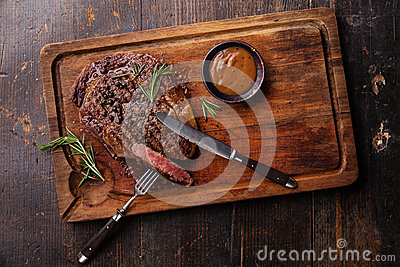 Grilled Black Angus Steak Ribeye And Pepper Sauce On Meat Cutting