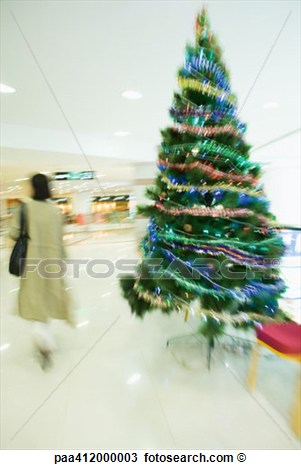 Shopper Walking Past Christmas Tree In Mall View Large Photo Image