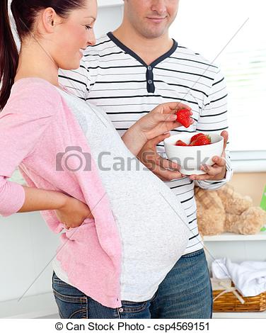 Portrait Of A Delighted Pregnant Woman Eating Strawberries And Of Her